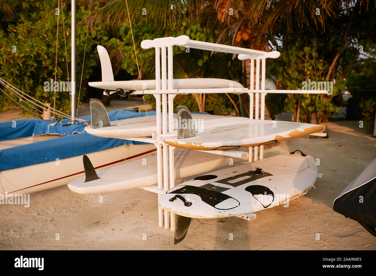 Old scratched and damaged surfboards on a rack stand for repair on the