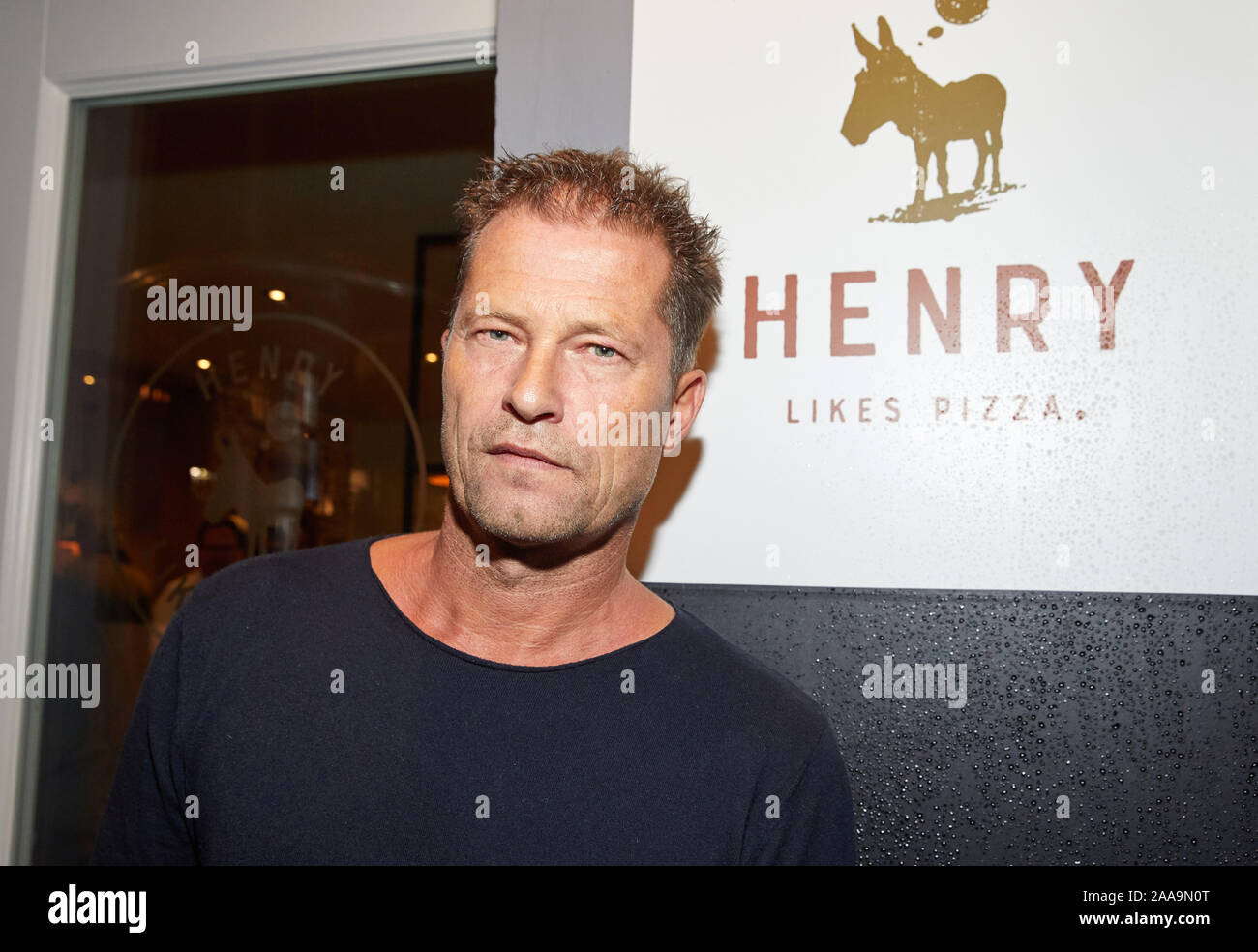 Hamburg, Germany. 20th Nov, 2019. Til Schweiger, actor and entrepreneur, stands in front of the entrance with the logo during the opening of his second restaurant 'Henry likes Pizza'. Credit: Georg Wendt/dpa/Alamy Live News Stock Photo