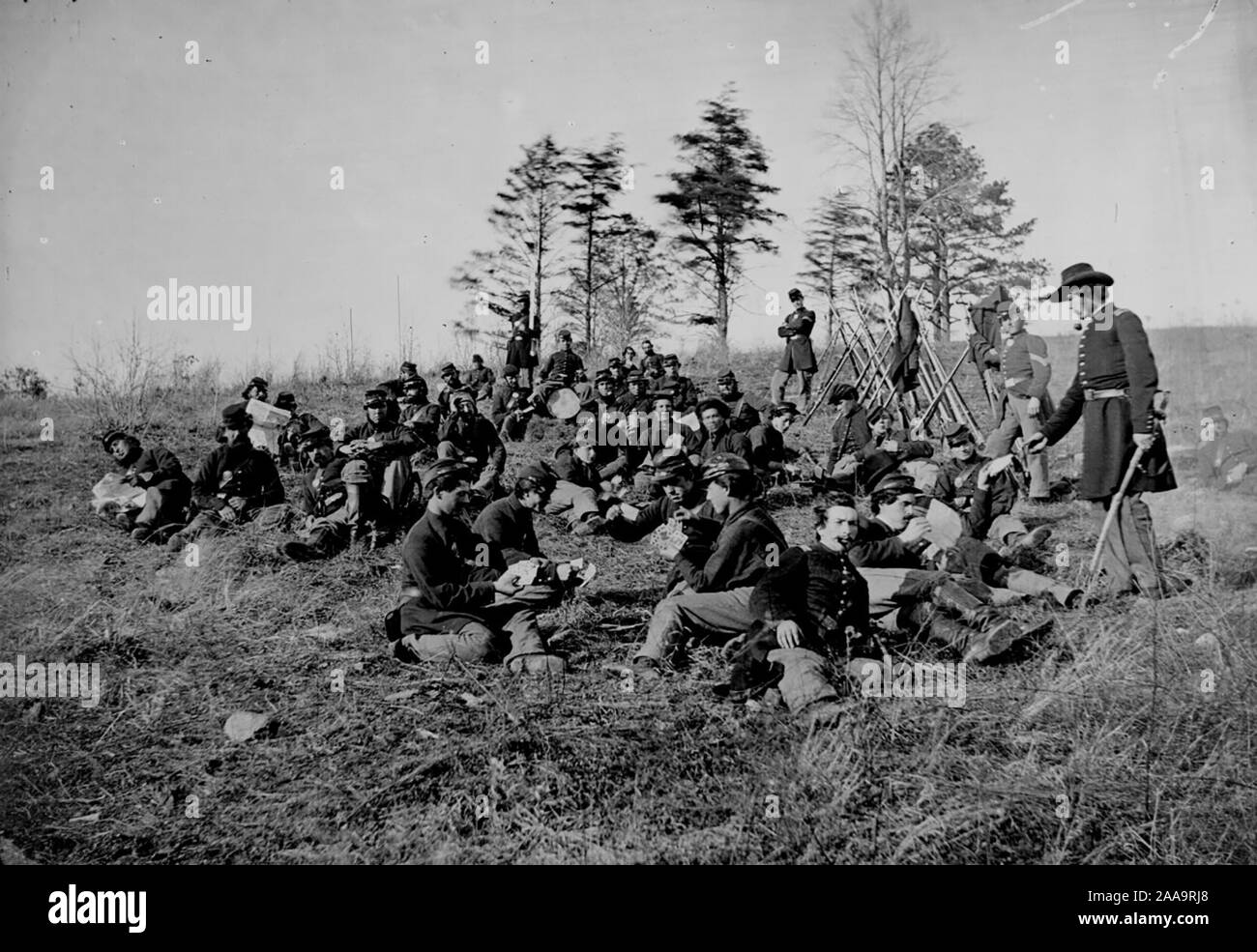 Civil War soldiers at rest after drill, Petersburg, Va., 1864. The soldiers are seated reading letters and papers and playing cards. Stock Photo