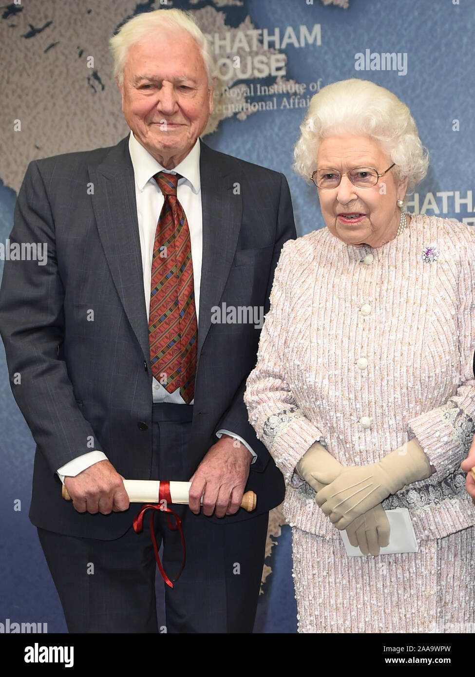 Queen Elizabeth II alongside Sir David Attenborough after she presented both him and Julian Hector, Head of the BBC Natural History Unit, the 2019 Chatham House Prize at the Royal institute of International Affairs, Chatham House, London. Stock Photo