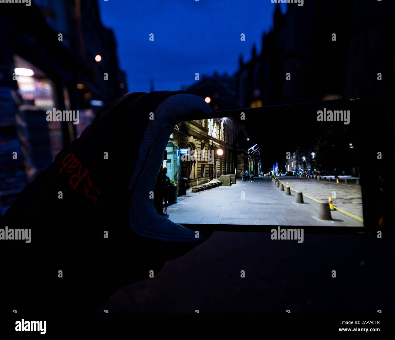 Edinburgh, Scotland, United Kingdom, 20th November 2019. Night Walk for Edinburgh created by Janet Cardiff & George Bures Miller, commissioned by Fruitmarket Gallery. An interactive trail around the closes (alleys) of the Royal Mile is a free event as part of Edinburgh's Christmas events. Participants watch a story unfold on a mobile phone as they walk the same depicted streets Stock Photo