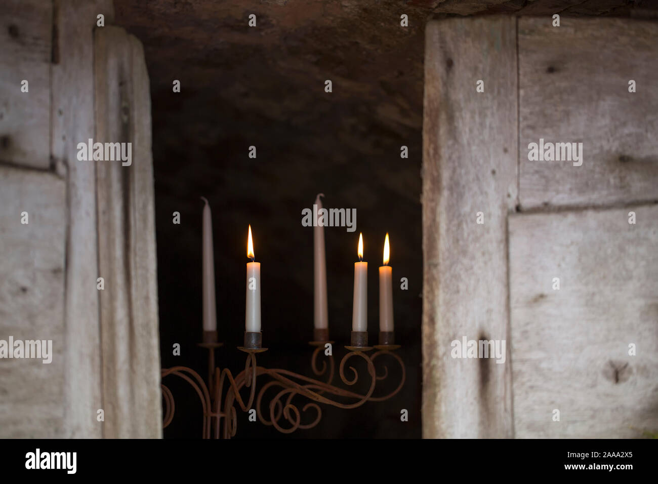 Candle sticks with candlelight in the entrance to a vaulted cellar Stock Photo
