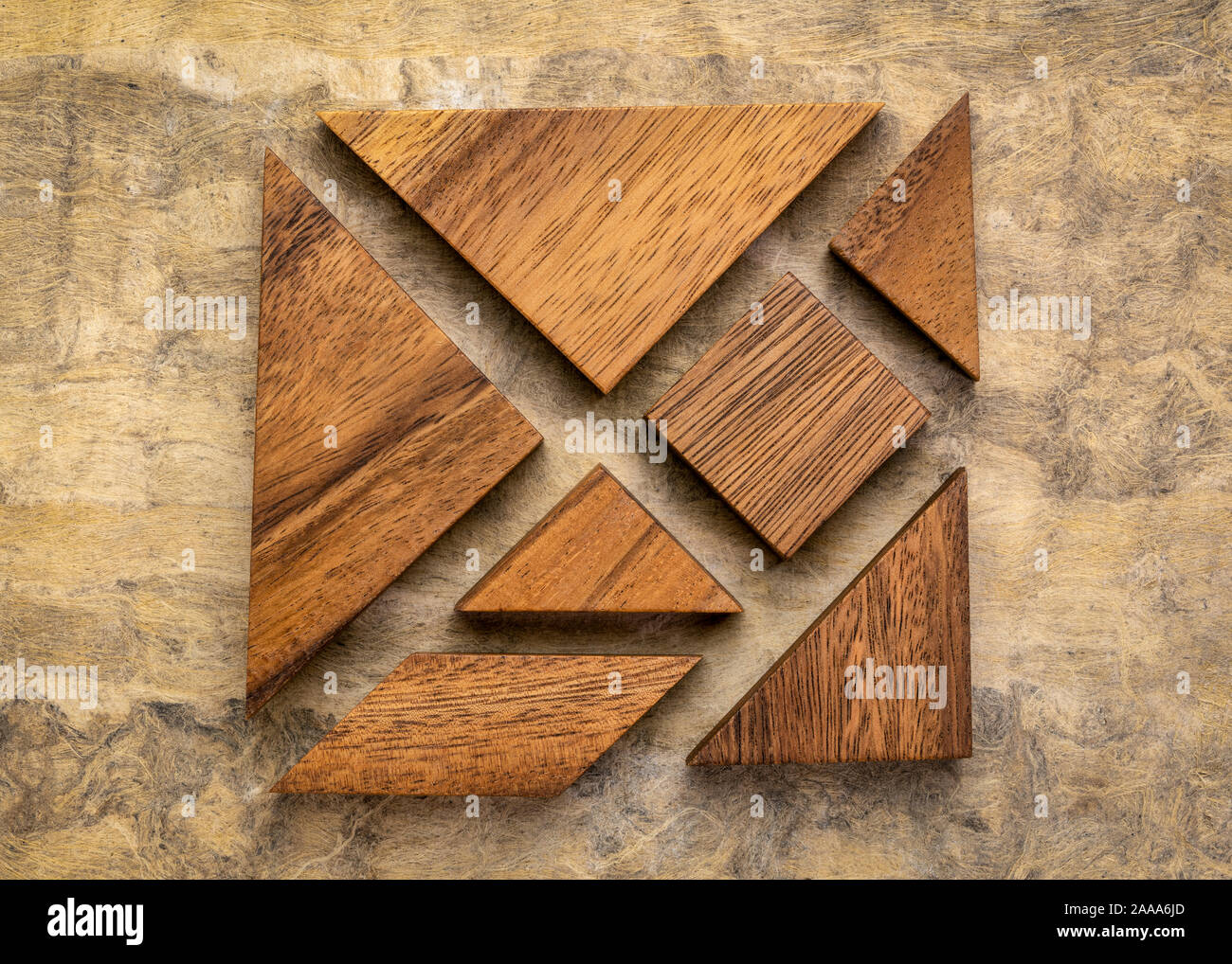 seven tangram wooden pieces, a traditional Chinese puzzle game, texture bark paper background Stock Photo