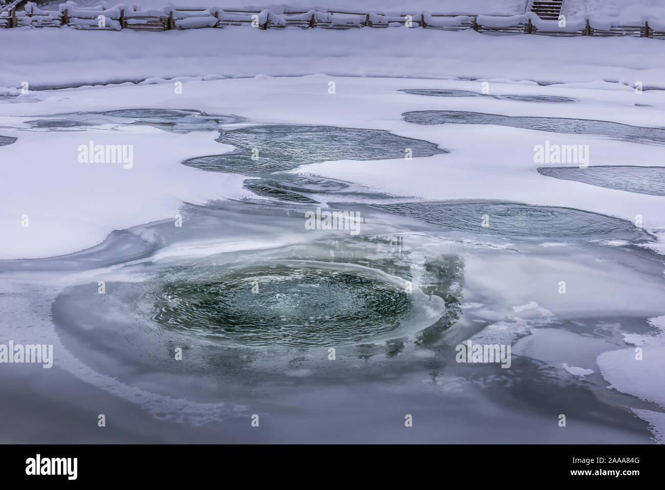 Holes in ice, covering aerated fish pond during winter season. Ice is