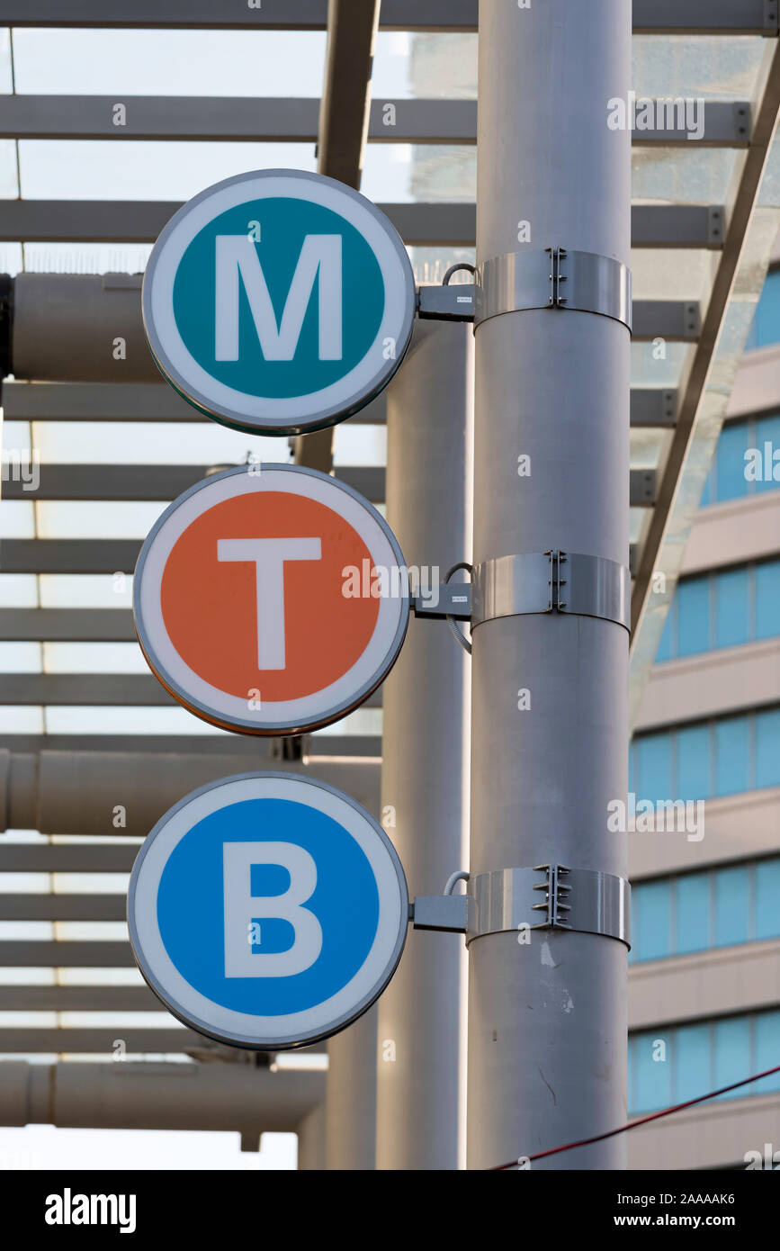 Three circular signs displaying an M, T and B indicating a Bus Stop  and a combined Sydney Metro and and Sydney Trains station at Chatswood, Sydney Stock Photo