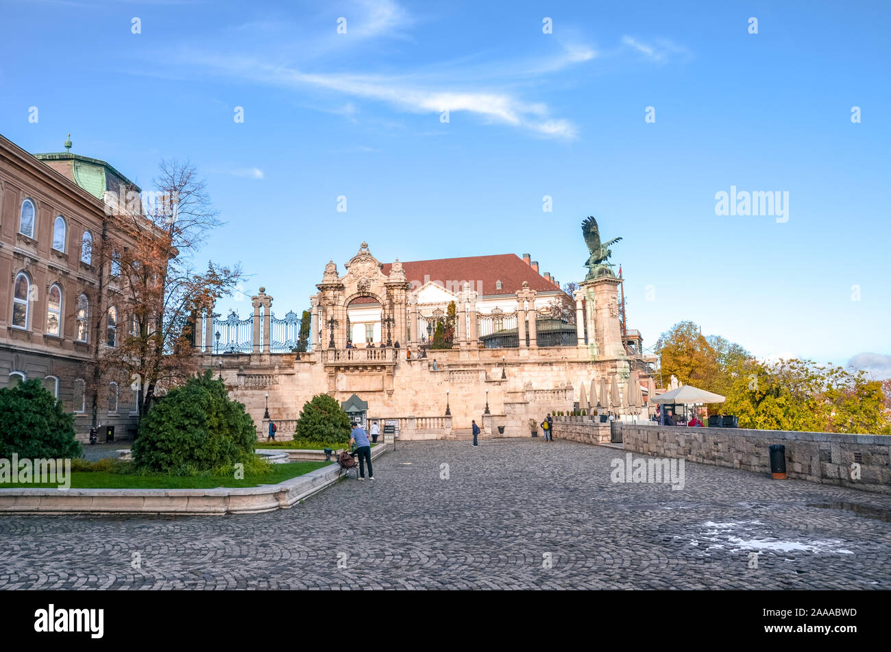 Budapest, Hungary - Nov 6, 2019: Historical courtyard of the Buda Castle. Statue of the mythological bird Turul and historical staircase in the background. Tourist landmark, people on the square. Stock Photo