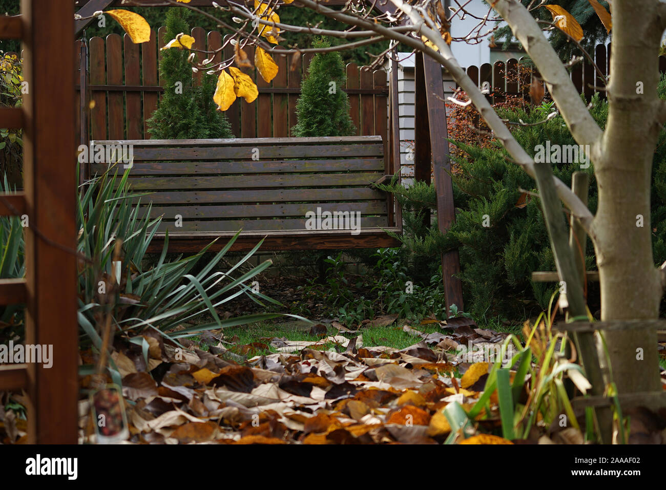 wooden, large swing in the autumn garden Stock Photo