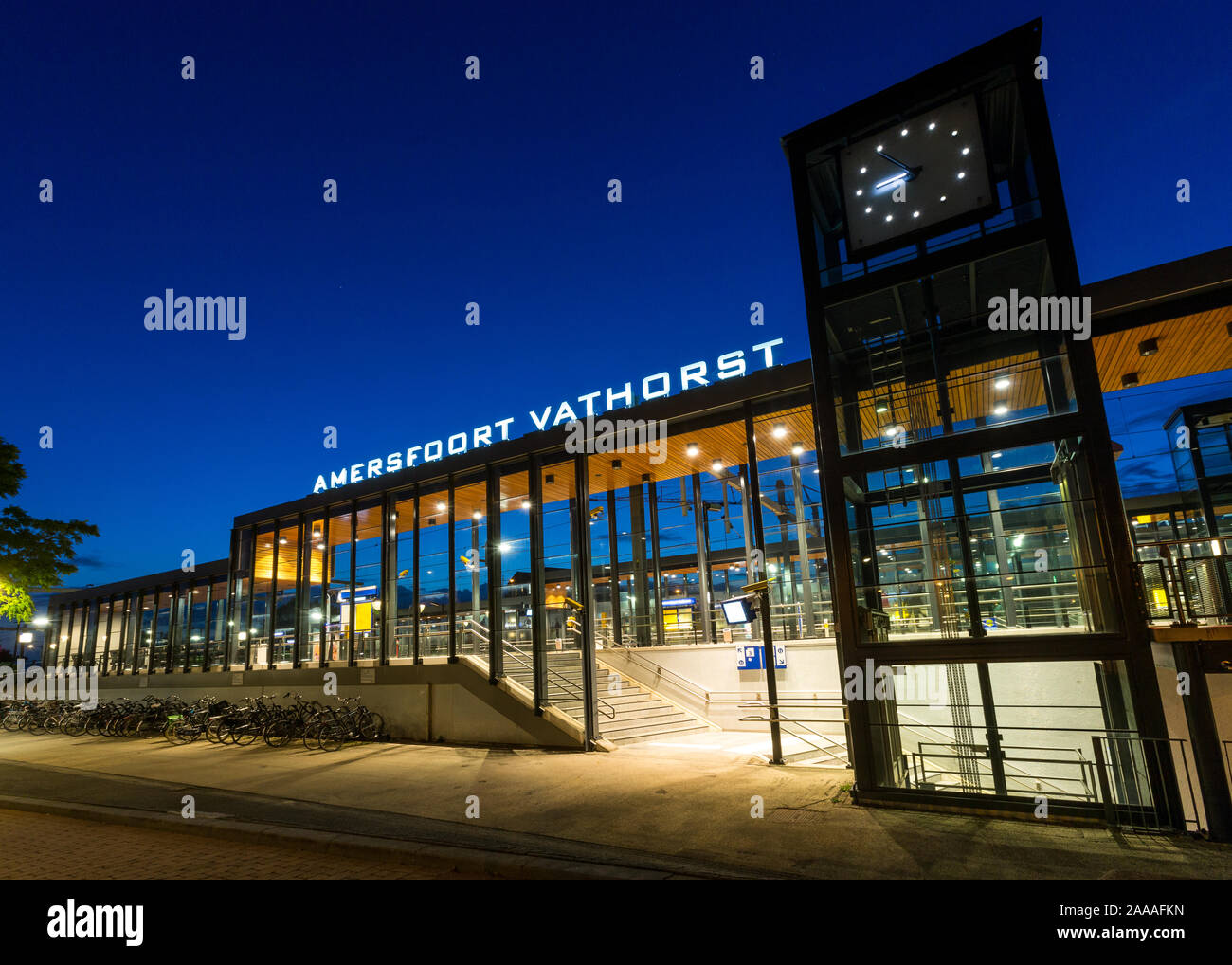 AMERSFOORT, THE NETHERLANDS - September 08, 2019: Illuminated train station Amersfoort Vathorst during blue hour with empty platform and parked bikes Stock Photo