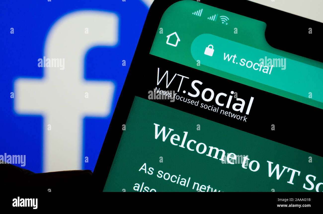 WT.Social website on the smartphone and Facebook logo on the background. WT:Social is  news focused social network form Wikipedia founder. Stock Photo