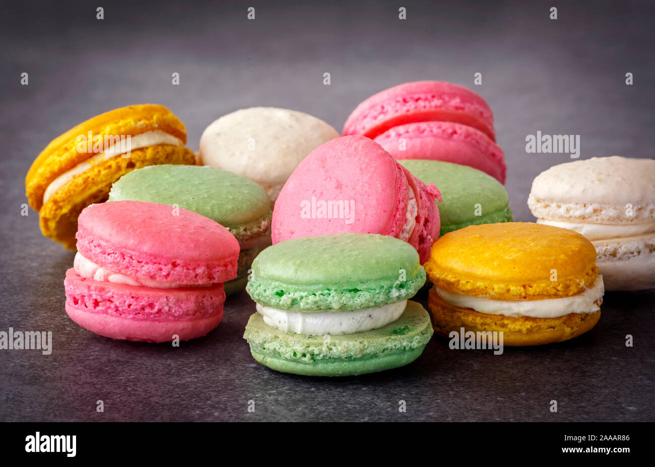 Pastel colored French macarons on a gray surface Stock Photo