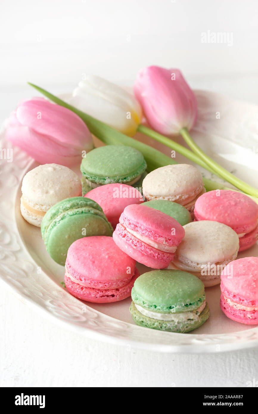 Spring tulips with pastel colored French macarons Stock Photo