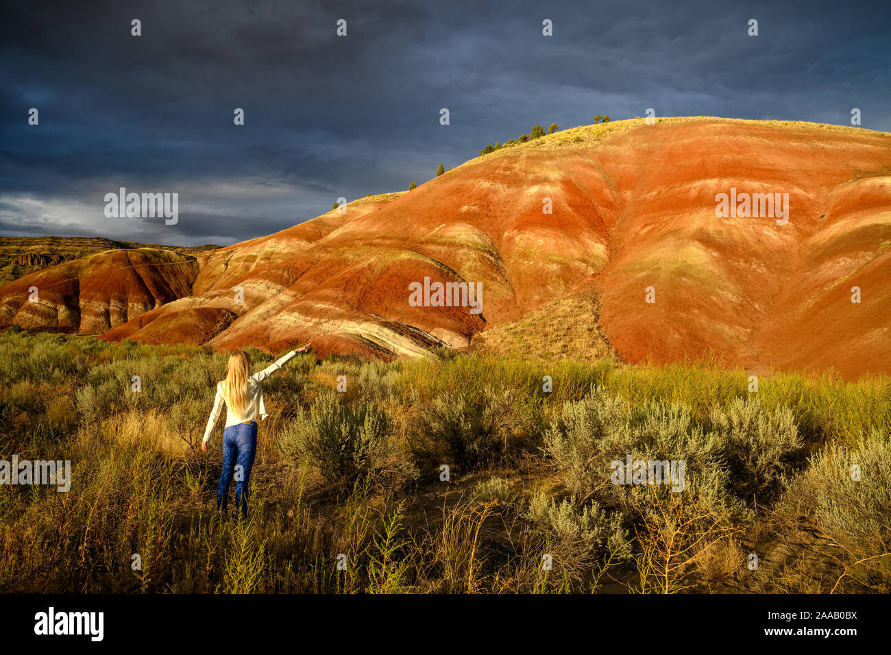 Casual young nature lover woman wonders the bright colors and picture perfect landscape at the Painted Hills Unit - John Day Fossil Beds Stock Photo
