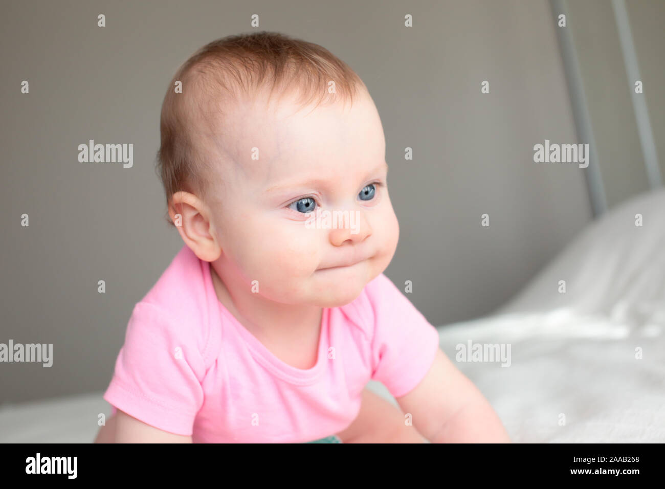 Close up Portrait of Cute 8 Month Old baby Girl with Big blue Eyes, Happy Baby Girl Stock Photo