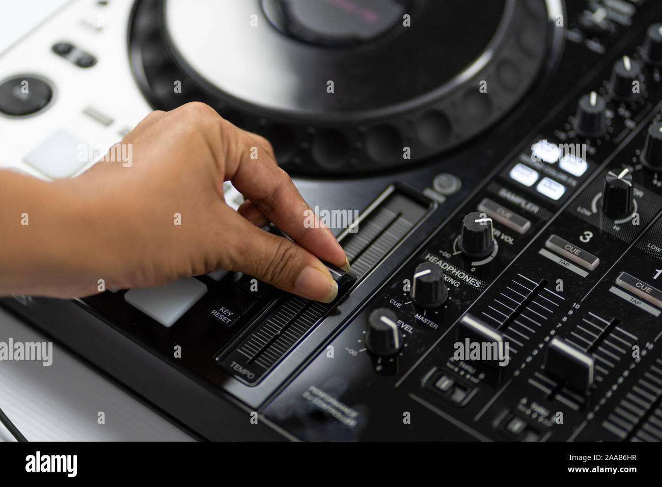 Hands of DJ mixing tracks on professional sound mixer.Fashionable rings on fingers of girl disc