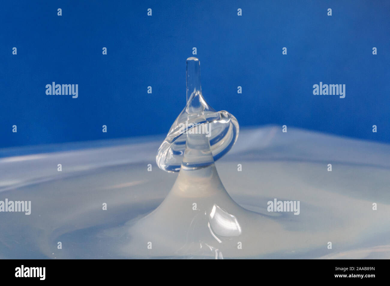 Water drop collision form with blue background Stock Photo