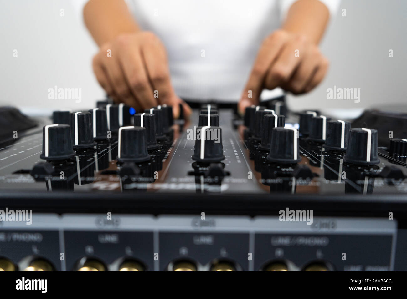 Hands of DJ mixing tracks on professional sound mixer.Fashionable rings on fingers of girl disc