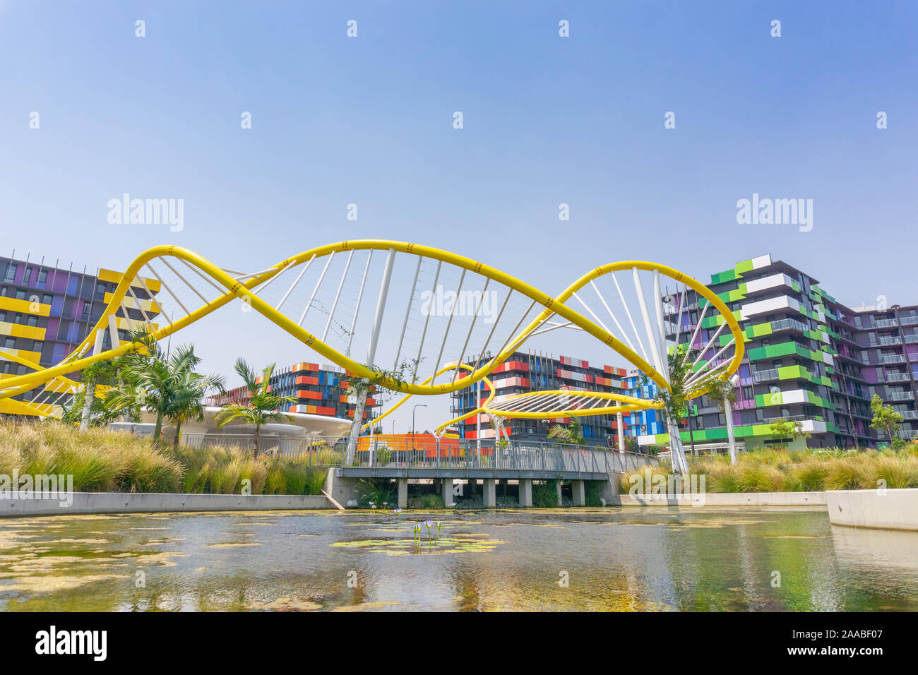 Gold Coast Australia - November 19 2019; Trendy colorful apartment buildings beyond modern bright yellow wave-like sculptural structure Stock Photo