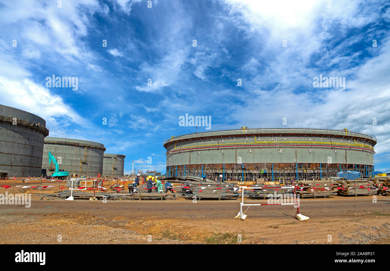 Construction site of Oil and gas industrial, Huge oil storage tank ,Heavy construction machine doing building  with the workers. Stock Photo