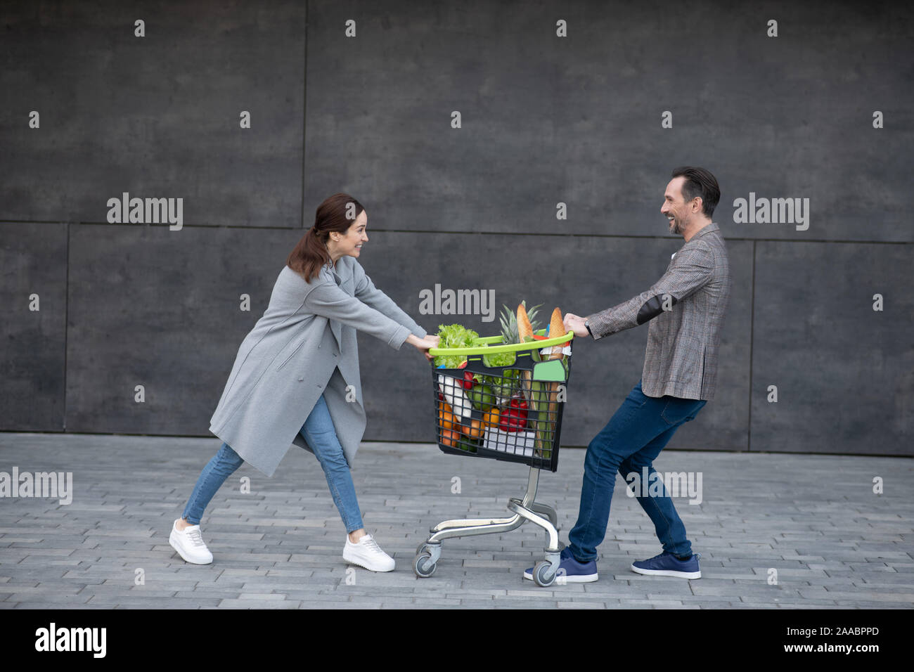 Cheerful couple having fun outside after buying groceries at the weekend Stock Photo