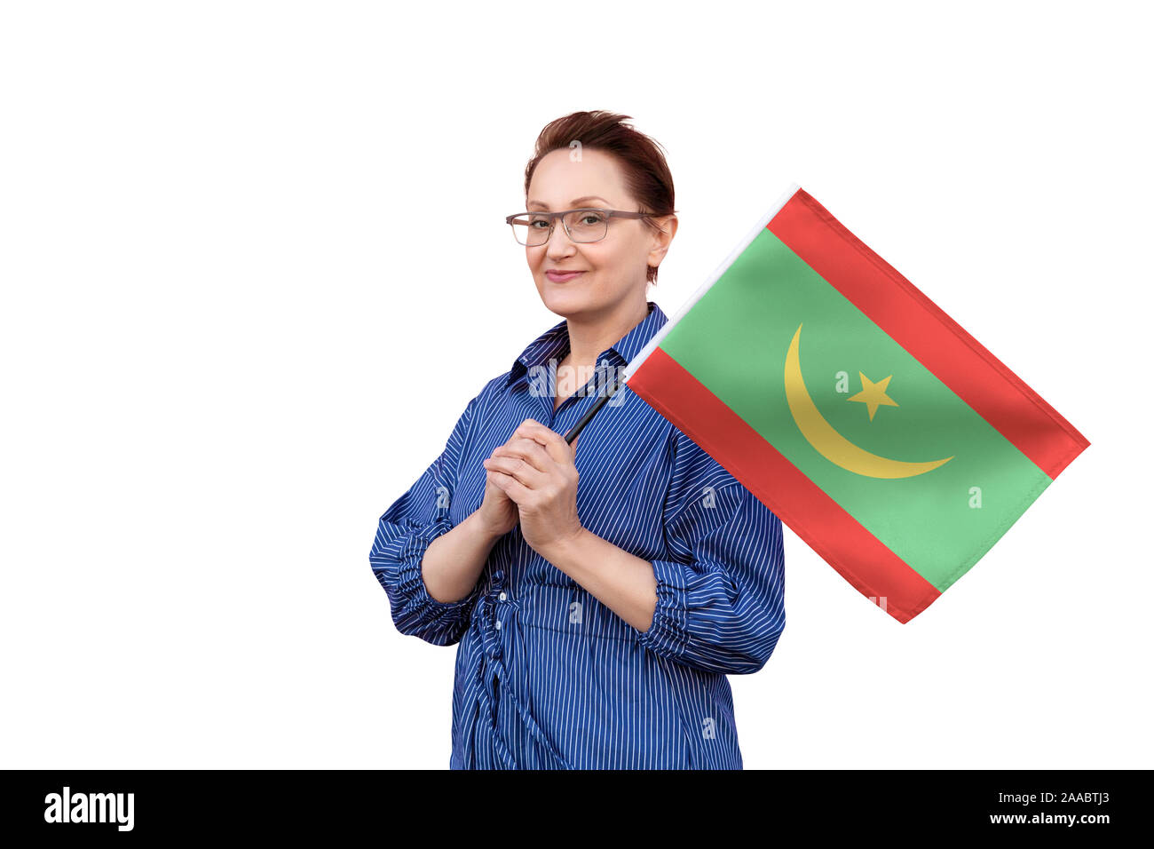 Mauritania flag. Woman holding Mauritanian flag. Nice portrait of middle aged lady 40 50 years old holding a large flag isolated on white background. Stock Photo