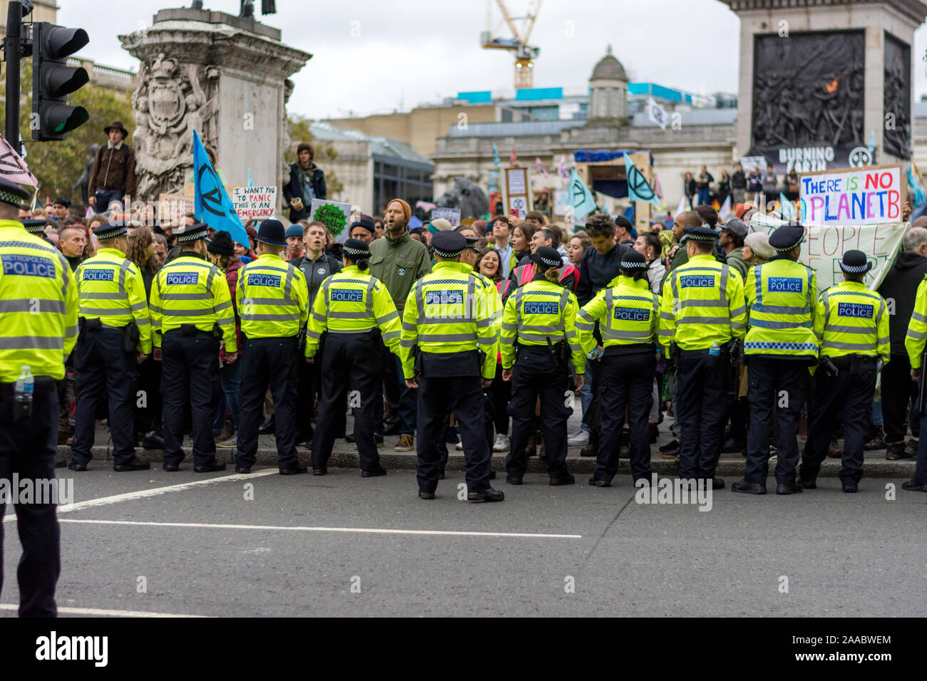 London, England –October 10, 2019: Police forces overlooking Extinction Rebellion protesters in Trafalgar Square London Stock Photo
