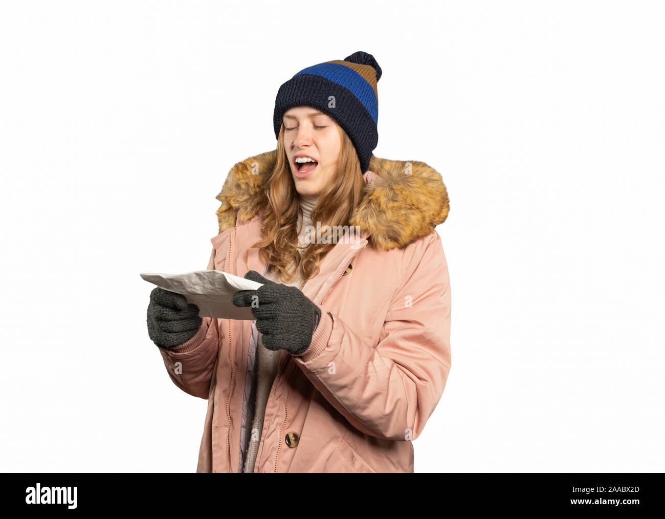 A young woman in winter clothes is holding a handkerchief and has to sneeze Stock Photo
