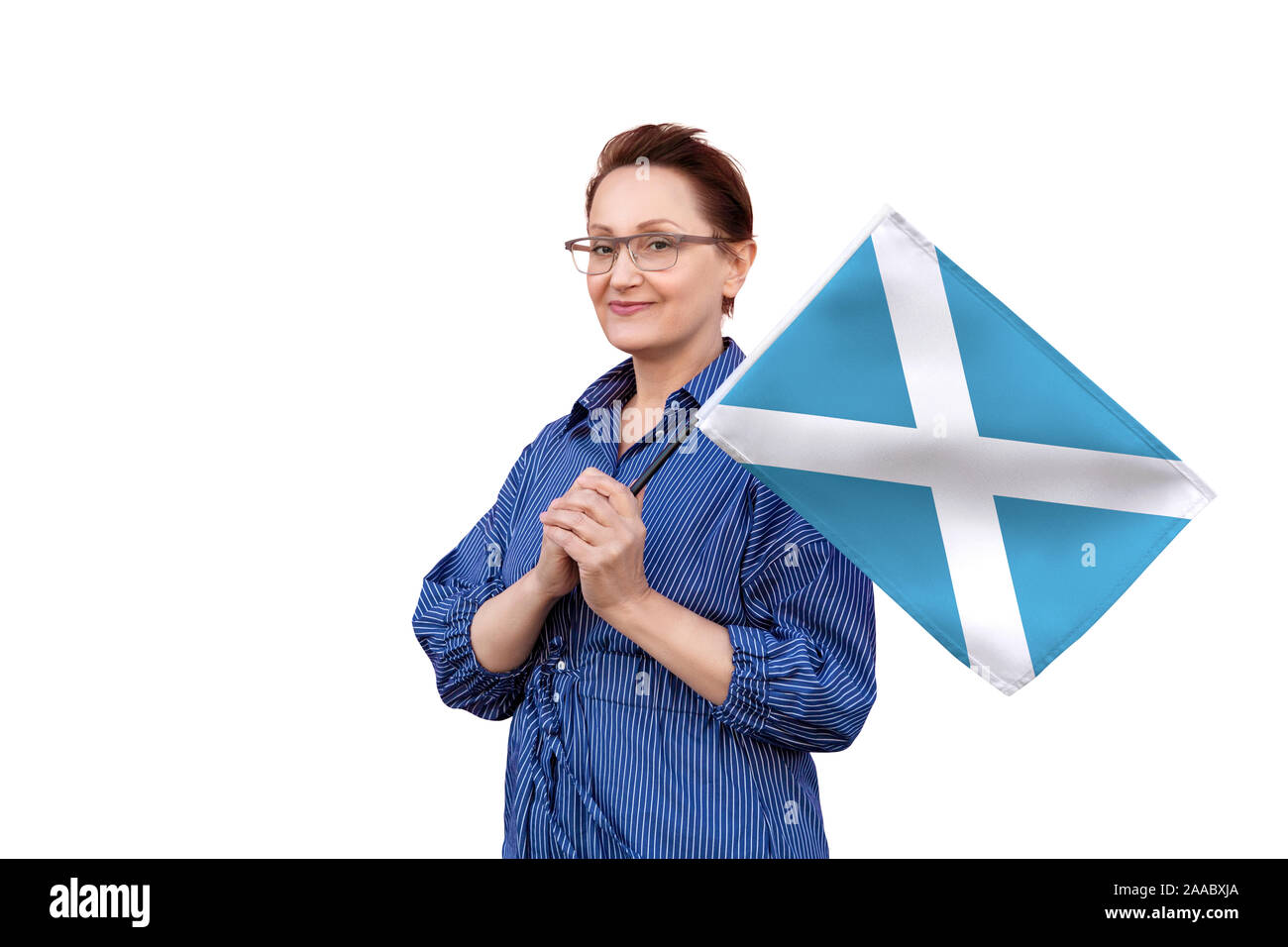 Scotland flag. Woman holding Scottish flag. Nice portrait of middle aged lady 40 50 years old holding a large flag isolated on white background. Stock Photo