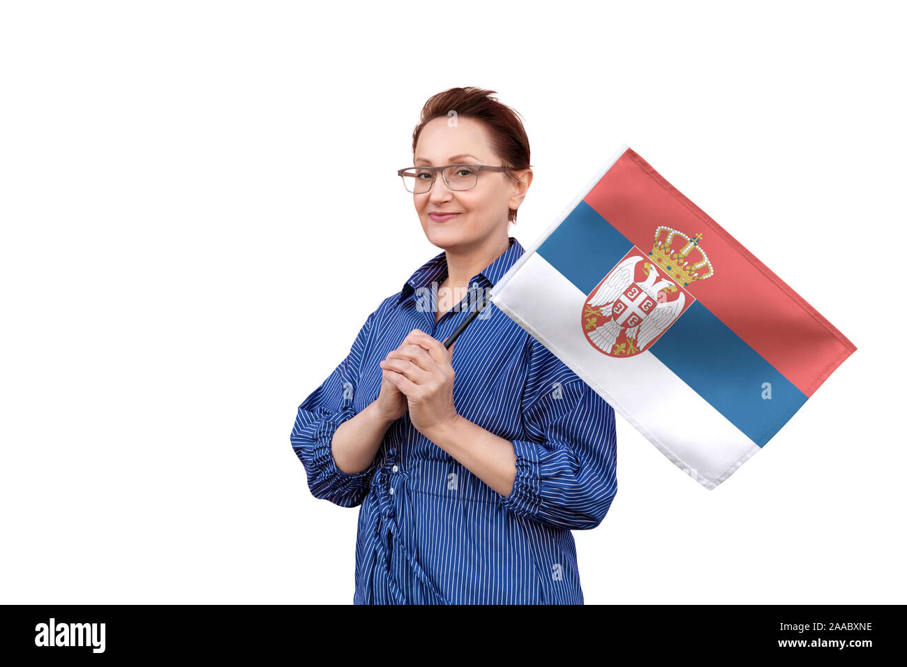 Serbia flag. Woman holding Serbian flag. Nice portrait of middle aged lady 40 50 years old holding a large flag isolated on white background. Stock Photo