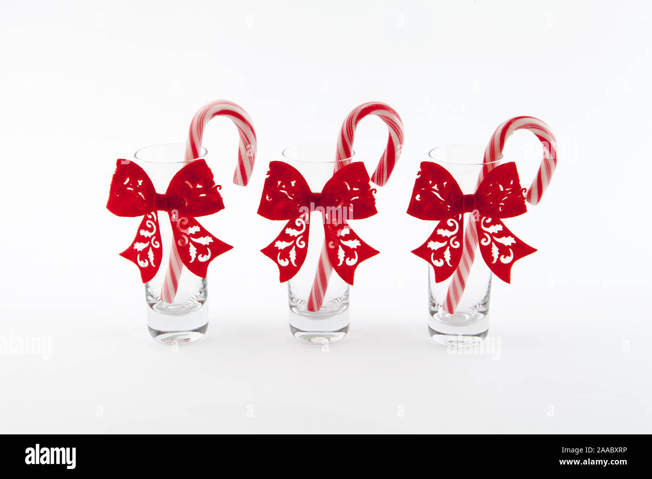 three traditional christmas candies cane in the glass on a white