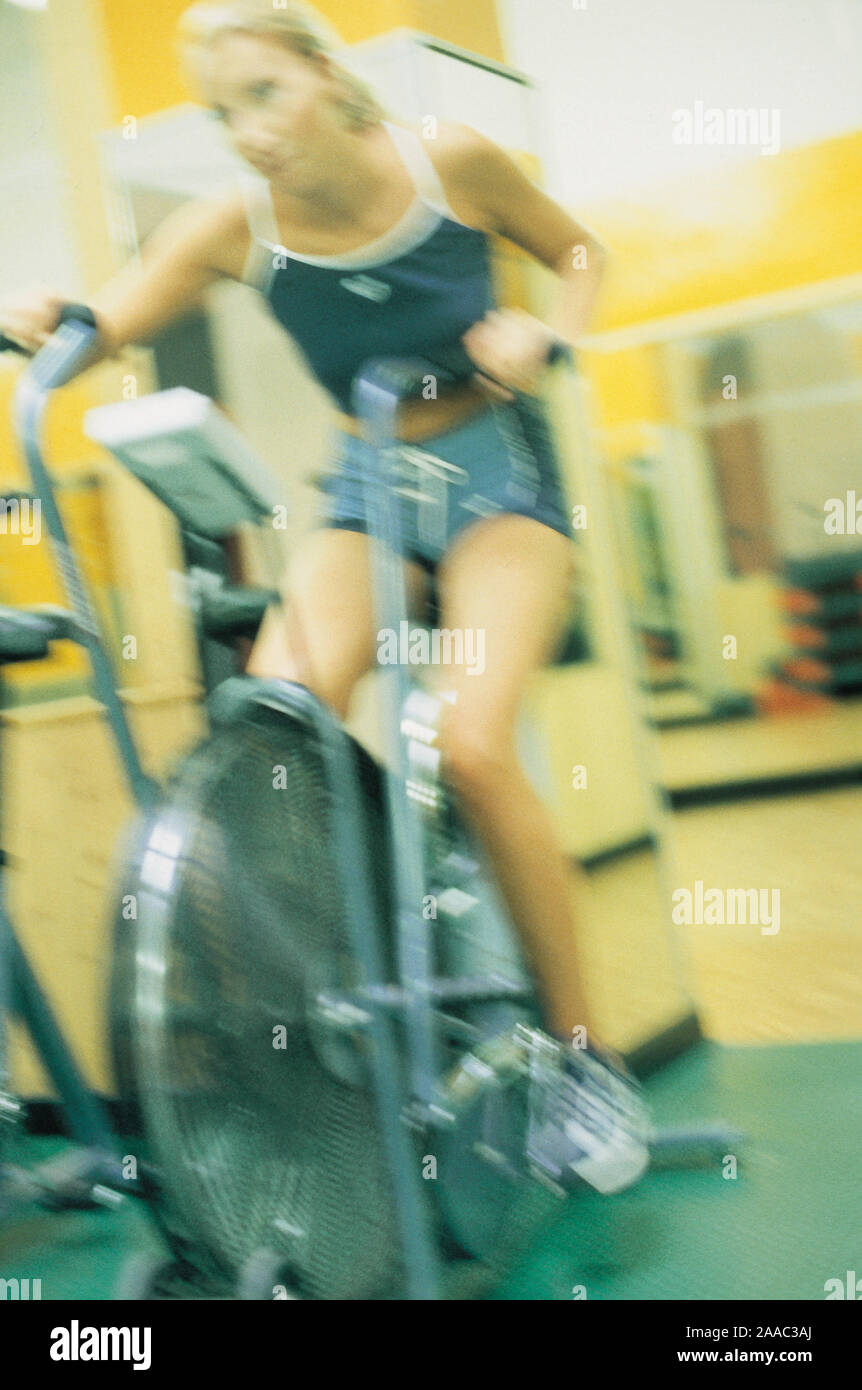woman on a cyclette in gym Stock Photo - Alamy