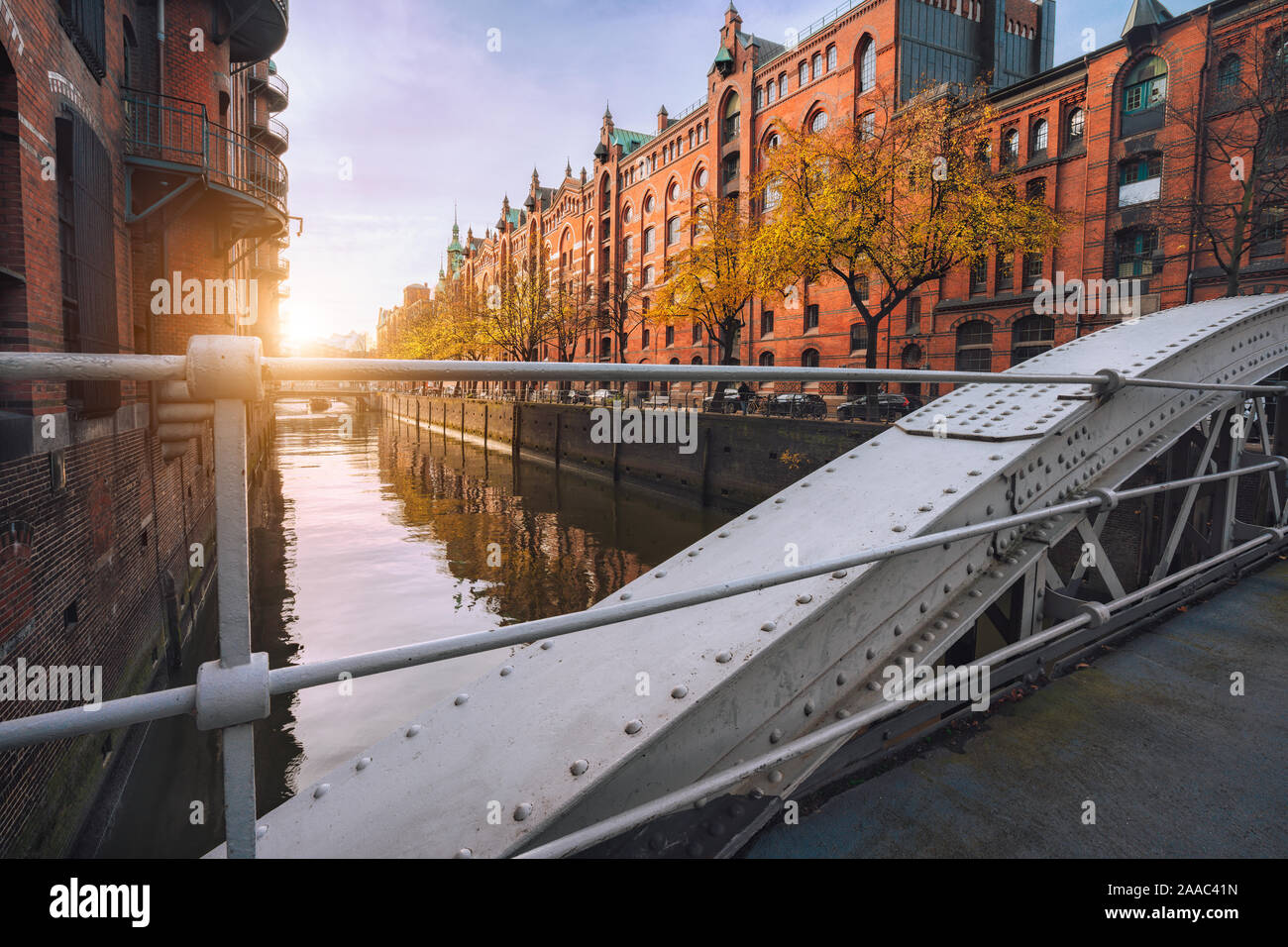 Arch bridge over canals in the Speicherstadt of Hamburg, Germany, Europe. Historical red brick building lit by warm soft golden sunset light. Stock Photo