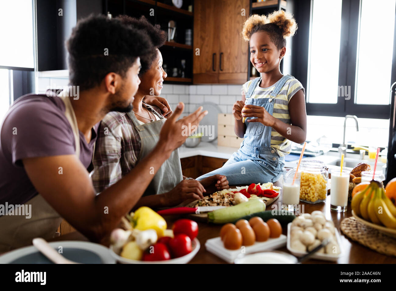 Happy african american family preparing healthy food together in