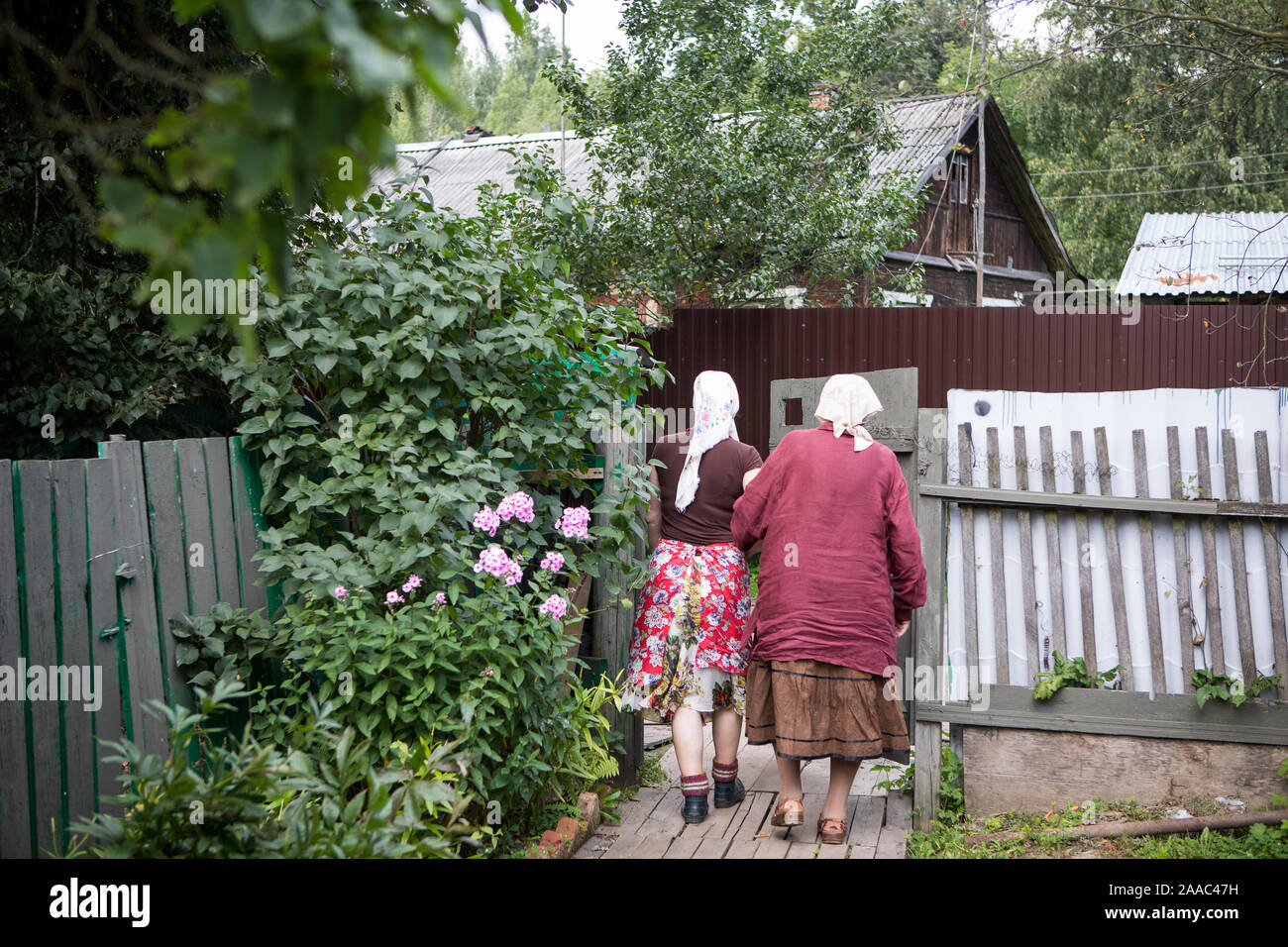 Two elderly women walk through the village yard, grandmother's life in ...