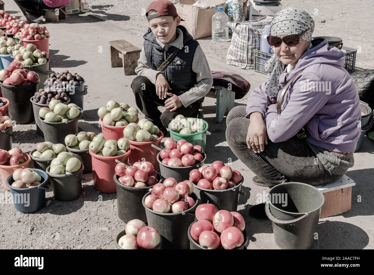 Women selling fruit in buckets, Balykchy, Kyrgyzstan Stock Photo