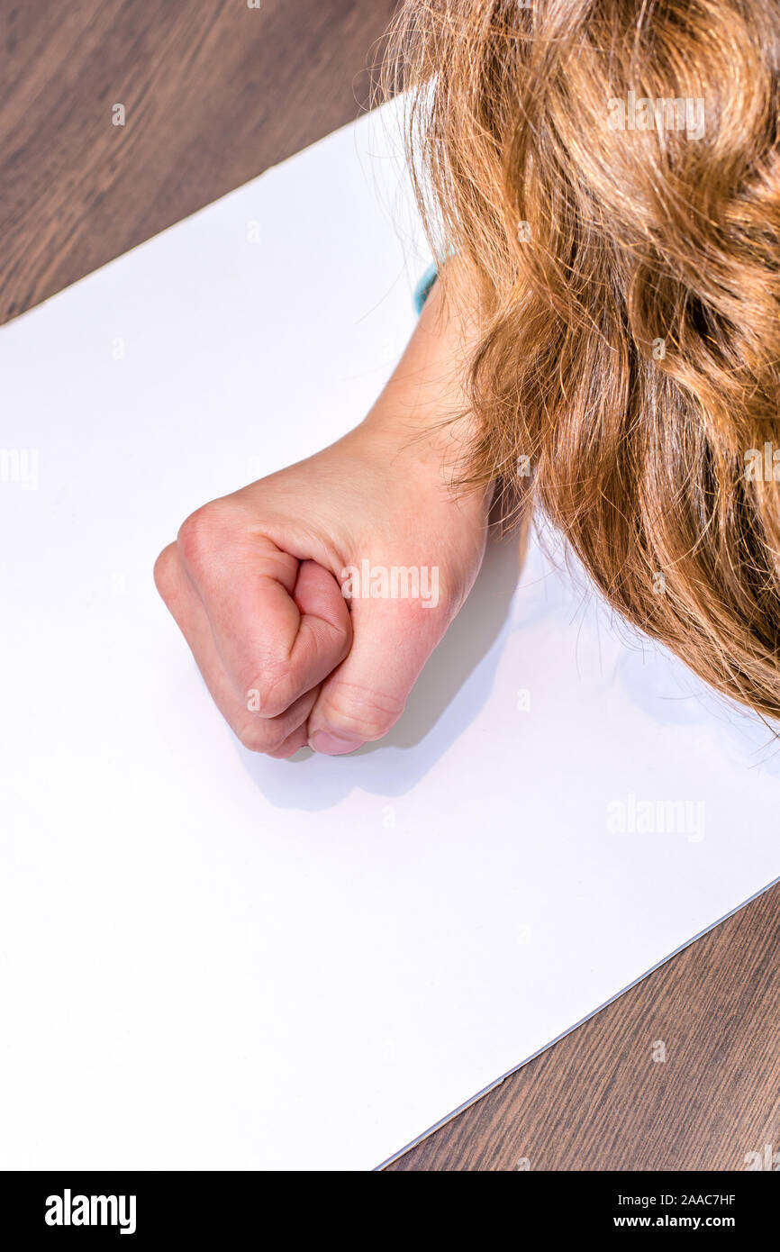 Woman is desperately clenching her fist on white paper as a template Stock Photo