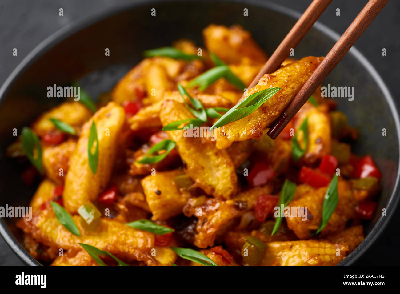 Baby Corn Manchurian dry looks like Schezwan Baby Corn in black bowl at