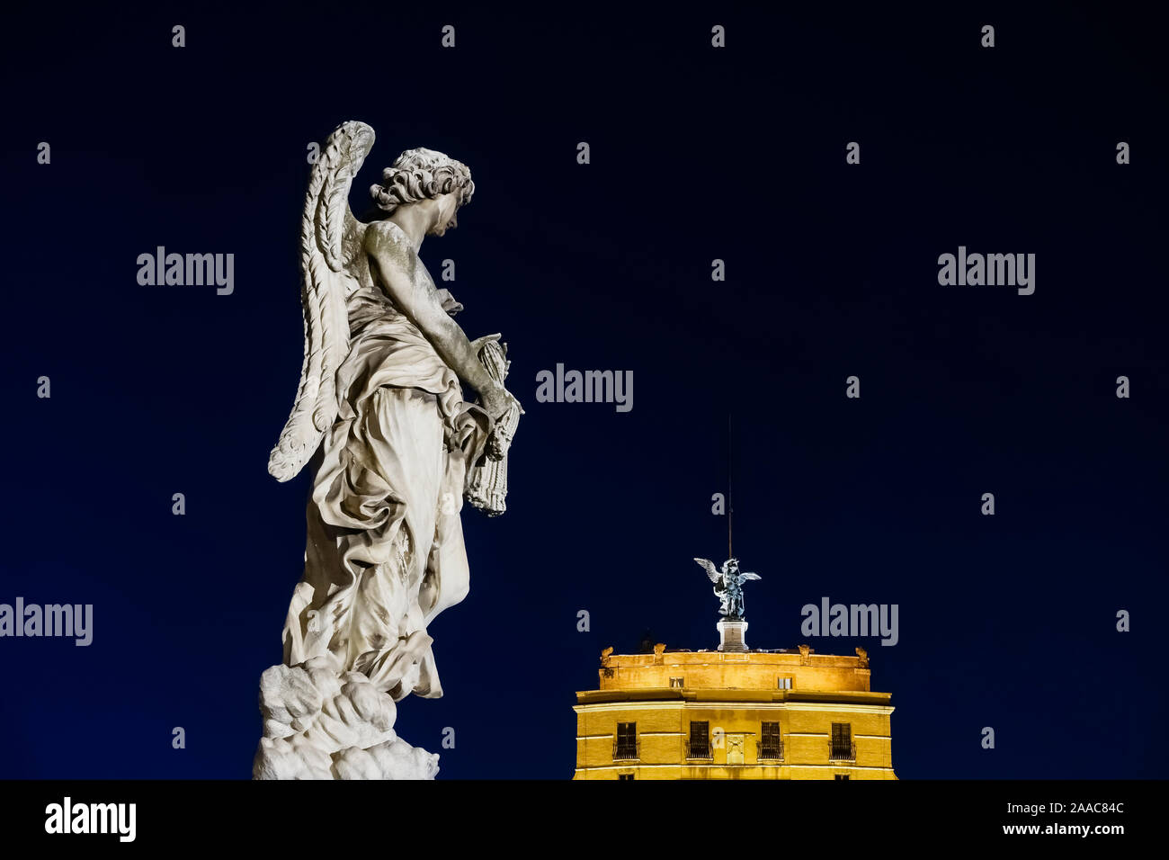 Angel with the Whips statue, sculpture on Holy Angel Bridge (Ponte Sant'Angelo) at night, against dark sky background. Copy space. Rome, Italy, Europe Stock Photo