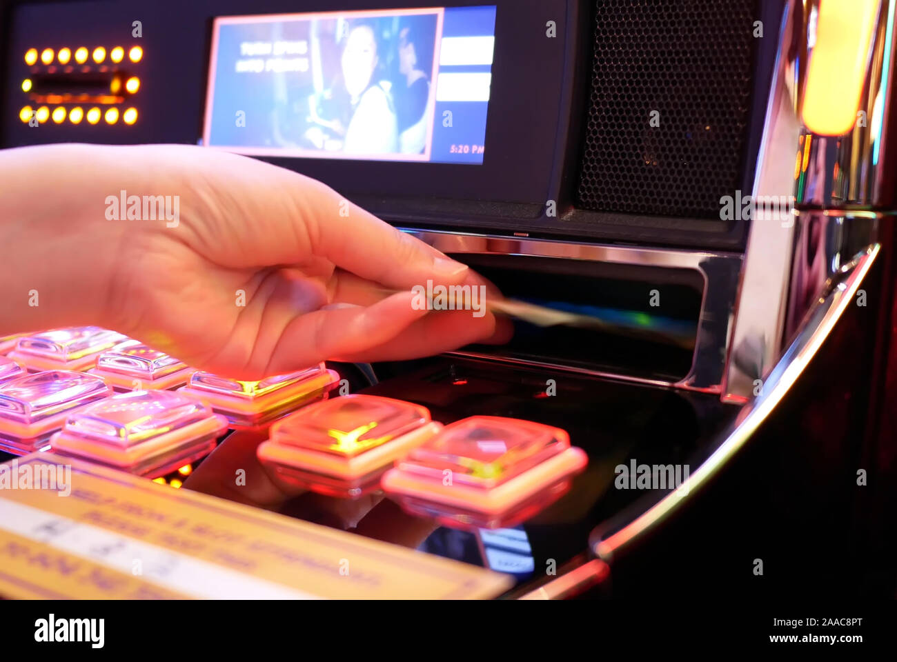 Coquitlam, BC, Canada - May 31, 2019 : Motion of woman inserts money on slot machine inside Casino Stock Photo