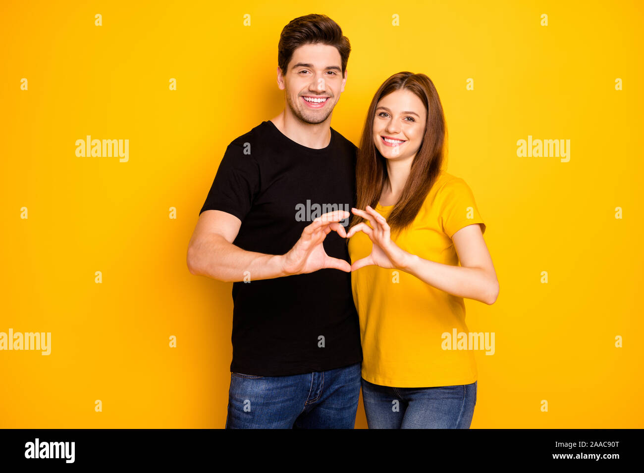 Photo of cheerful positive cute nice charming couple of two people  pondering over surprise for each other isolated over vivid color background  in black t-shirt Stock Photo