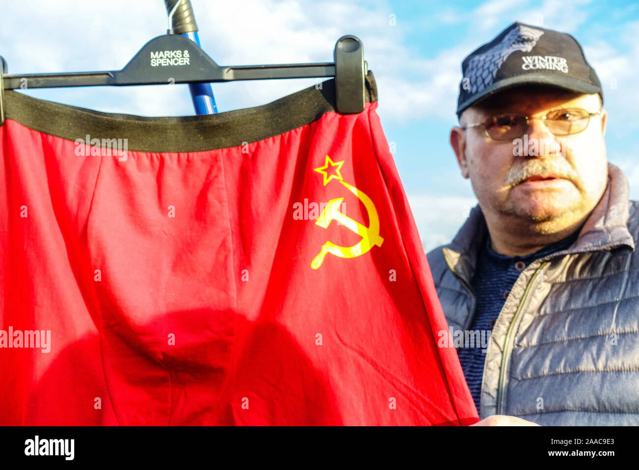 Man with red shorts on a coat hanger from Marks & Spencer symbol against President Zeman at a demonstration, Letna Prague Czech Republic Stock Photo