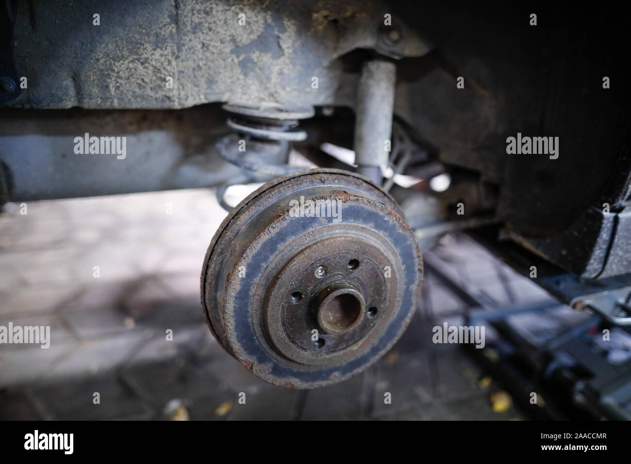 Shallow depth of field (selective focus) image with a rusty rear wheel hub of an old car. Stock Photo