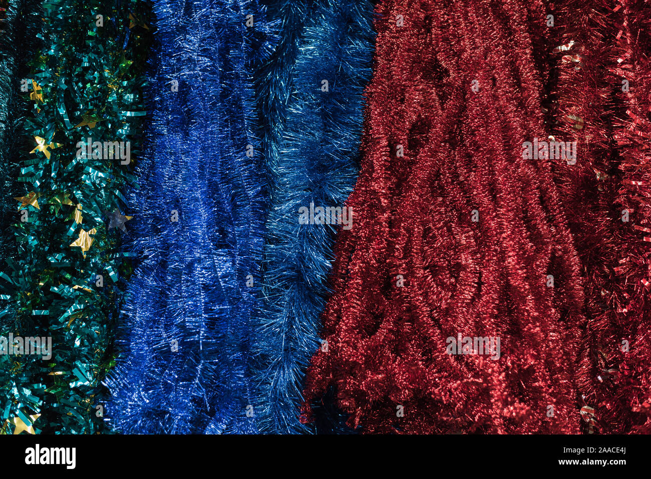 Multicolored garlands and tinsel on a store counter. Red, blue, green