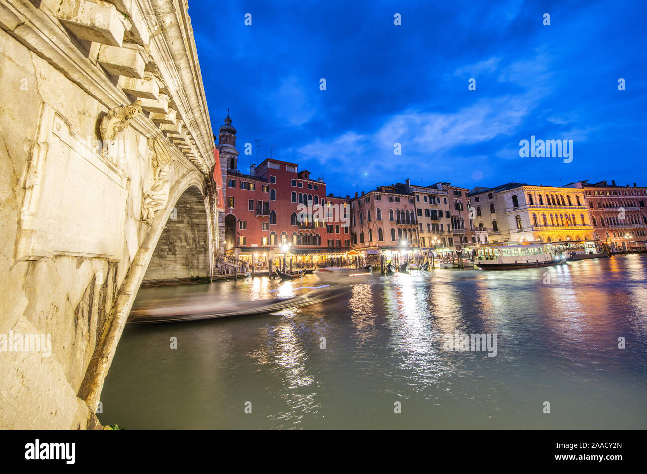 Rialto Bridge at night with city restaurants along grand canal, Venice, Italy. Stock Photo