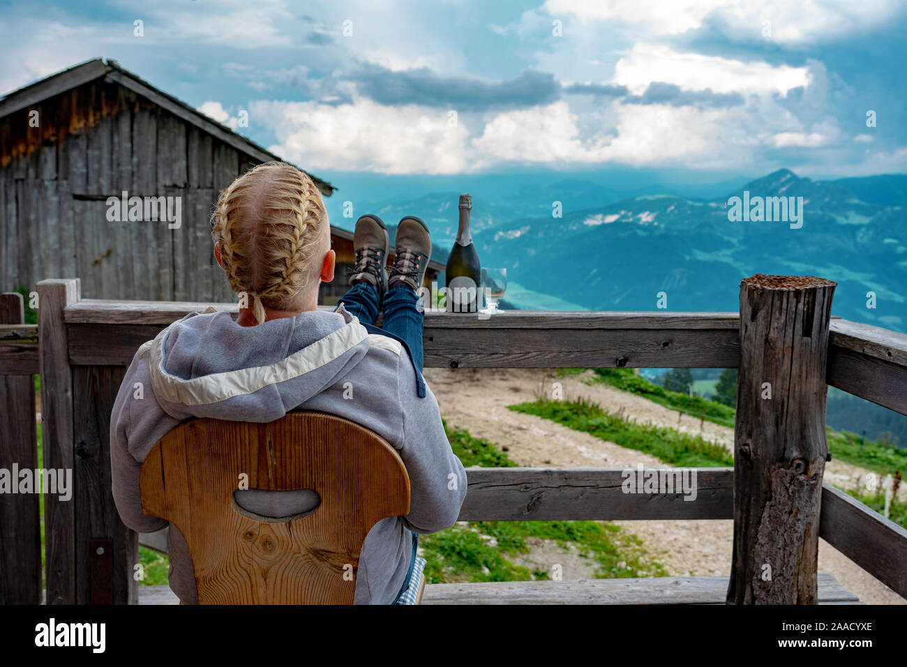 woman relaxing on an alm hut hutte terrasse in tyrol with mountain view . Stock Photo
