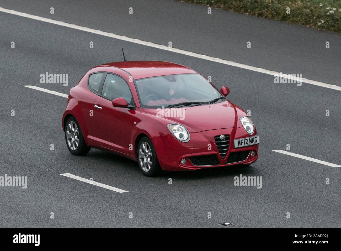 2012 red Alfa Romeo Mito Sprint Multiair TB; Vehicular traffic, transport, modern vehicles, saloon cars, south-bound motoring on the M61 motorway, UK Stock Photo