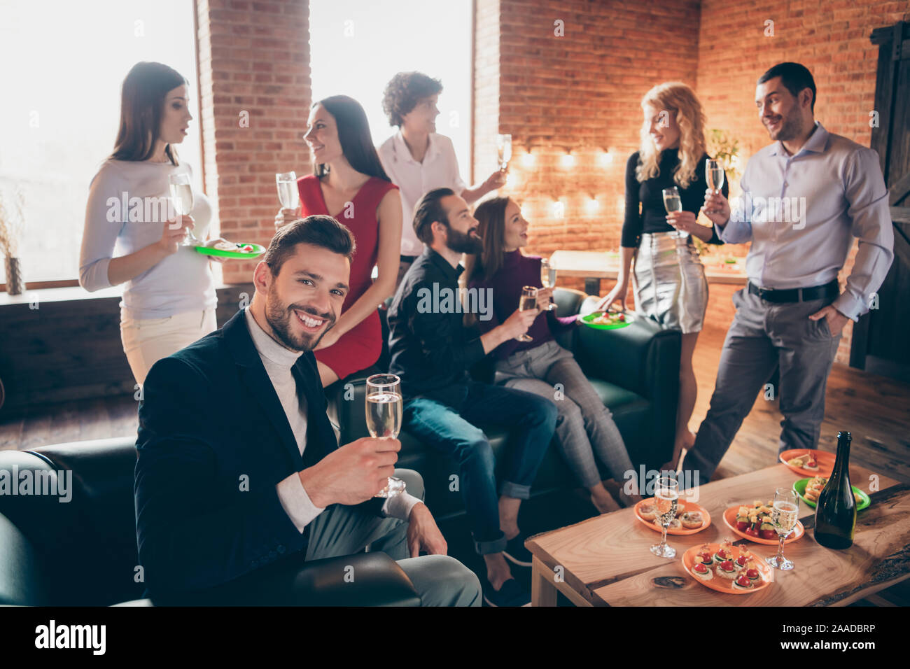 Photo of group festive birthday party chatting handsome guy raising glass drink golden wine eating snacks wear formalwear restaurant sitting near Stock Photo