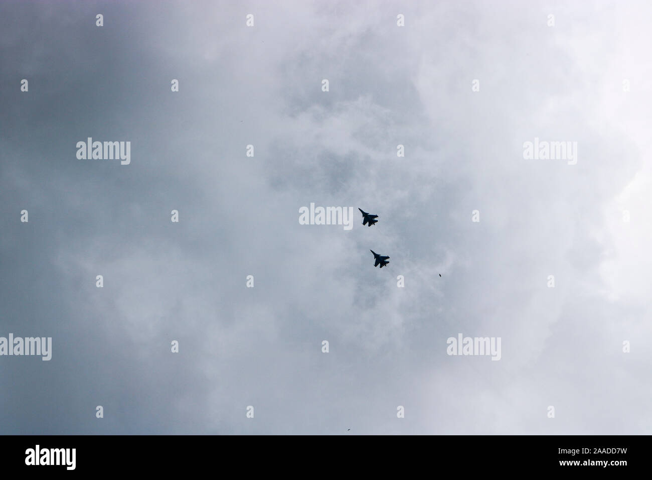 Two military fighters fly in the sky. Behind them stretches a condensation trail. Stock Photo