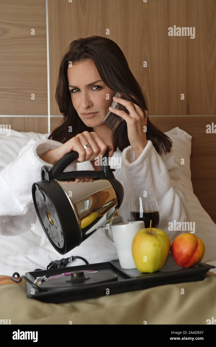 Junge muede Frau macht Fruehstueck im Bett Stock Photo