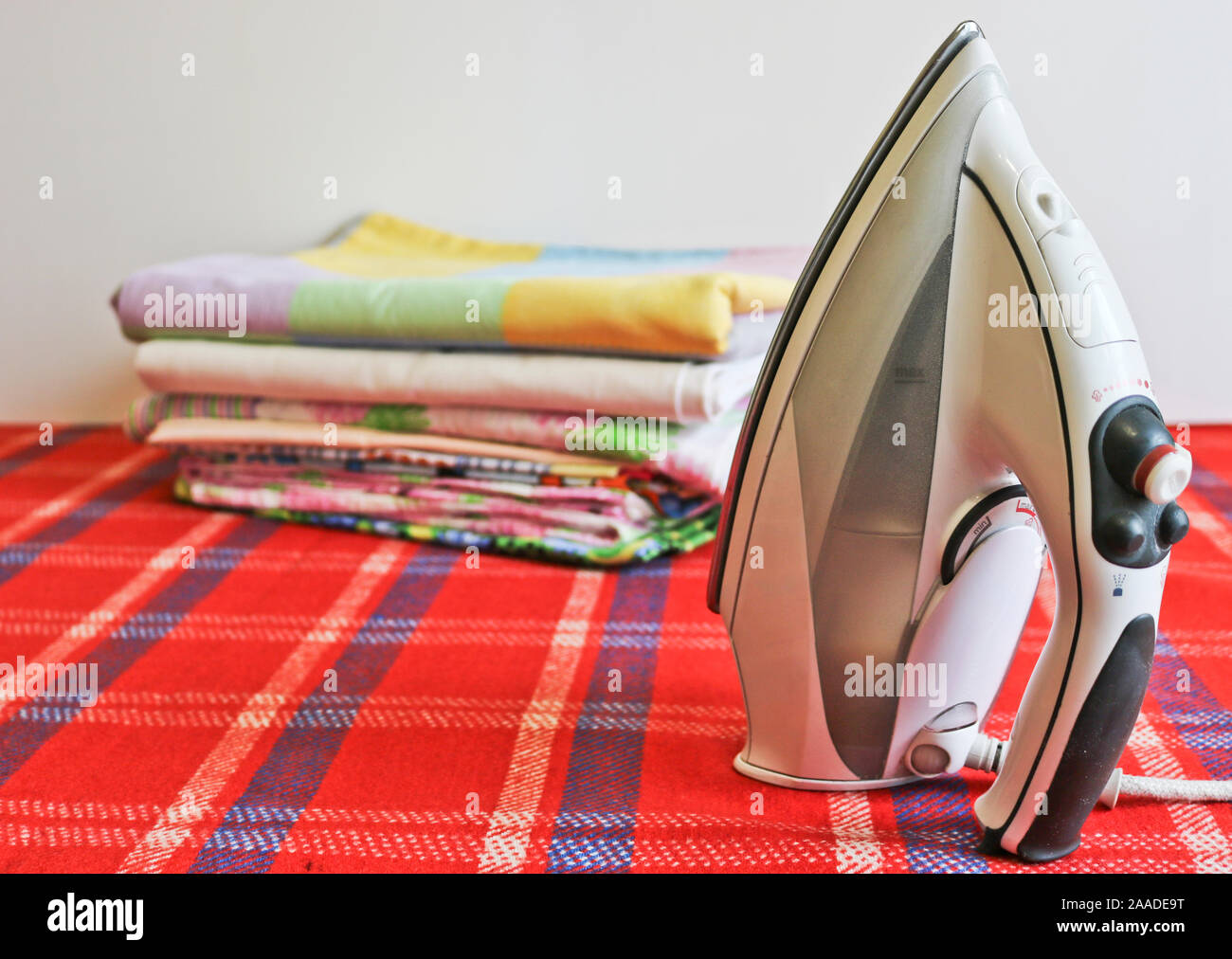 Modern iron and stack of ironed linen. Household chores Stock Photo Alamy