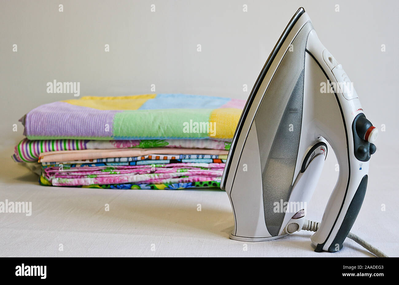Modern iron and stack of ironed linen. Household chores Stock Photo Alamy